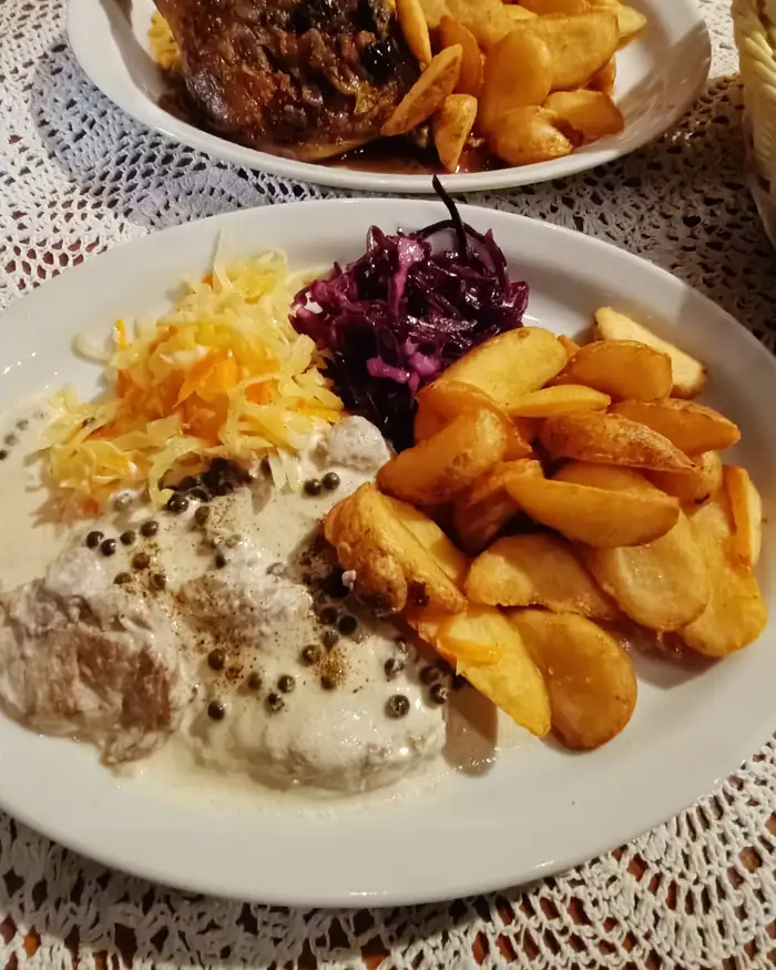 Kotlet z sosem pieczarkowym, cząstkami ziemniaków i surówkami